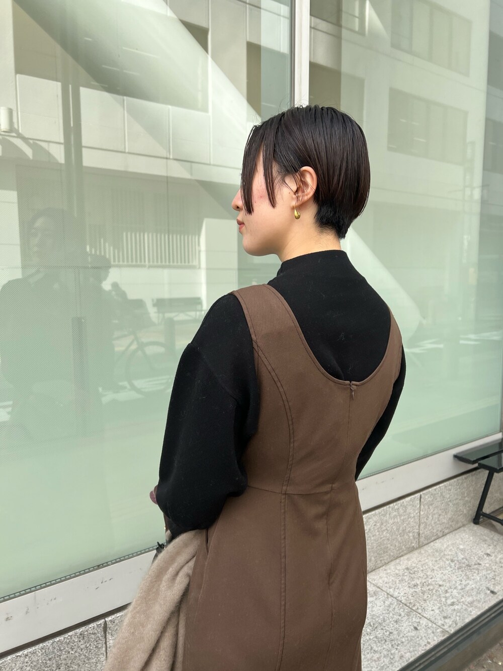 ブラック系のハンドバッグ、ベージュ系のブーツ、ベージュ系のカーディガン/ボレロを着用したレディースの秋コーディネートの6枚目の写真