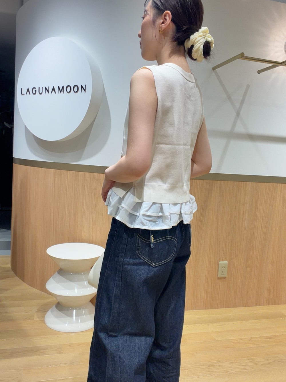 ホワイト系のニット/セーター、オレンジ系のサンダル、ブルー系のデニムパンツを着用したレディースの夏コーディネートの5枚目の写真
