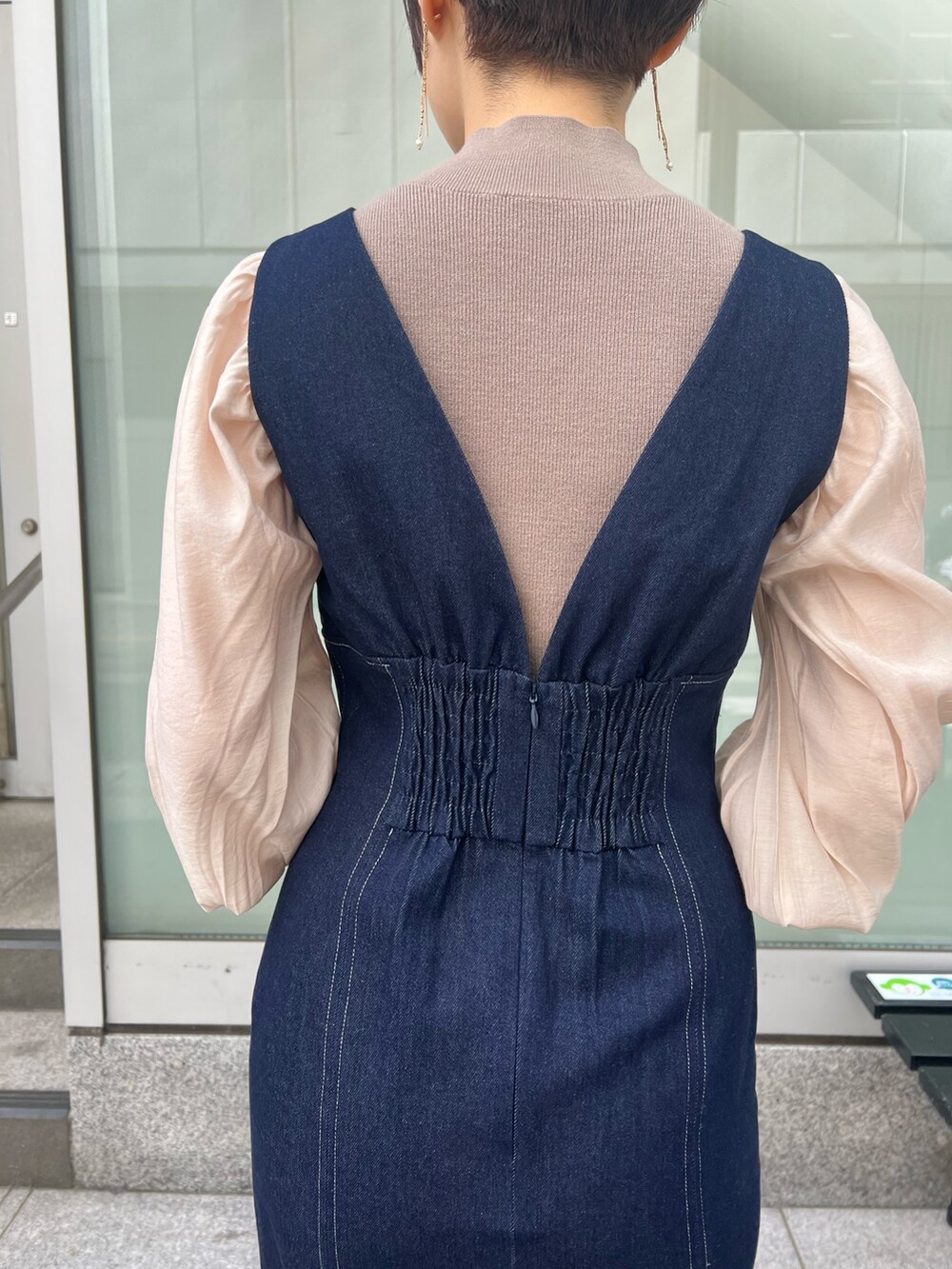 ベージュ系のカーディガン/ボレロ、レッド系のブーツ、ブラウン系のニット/セーターを着用したレディースの冬コーディネートの6枚目の写真