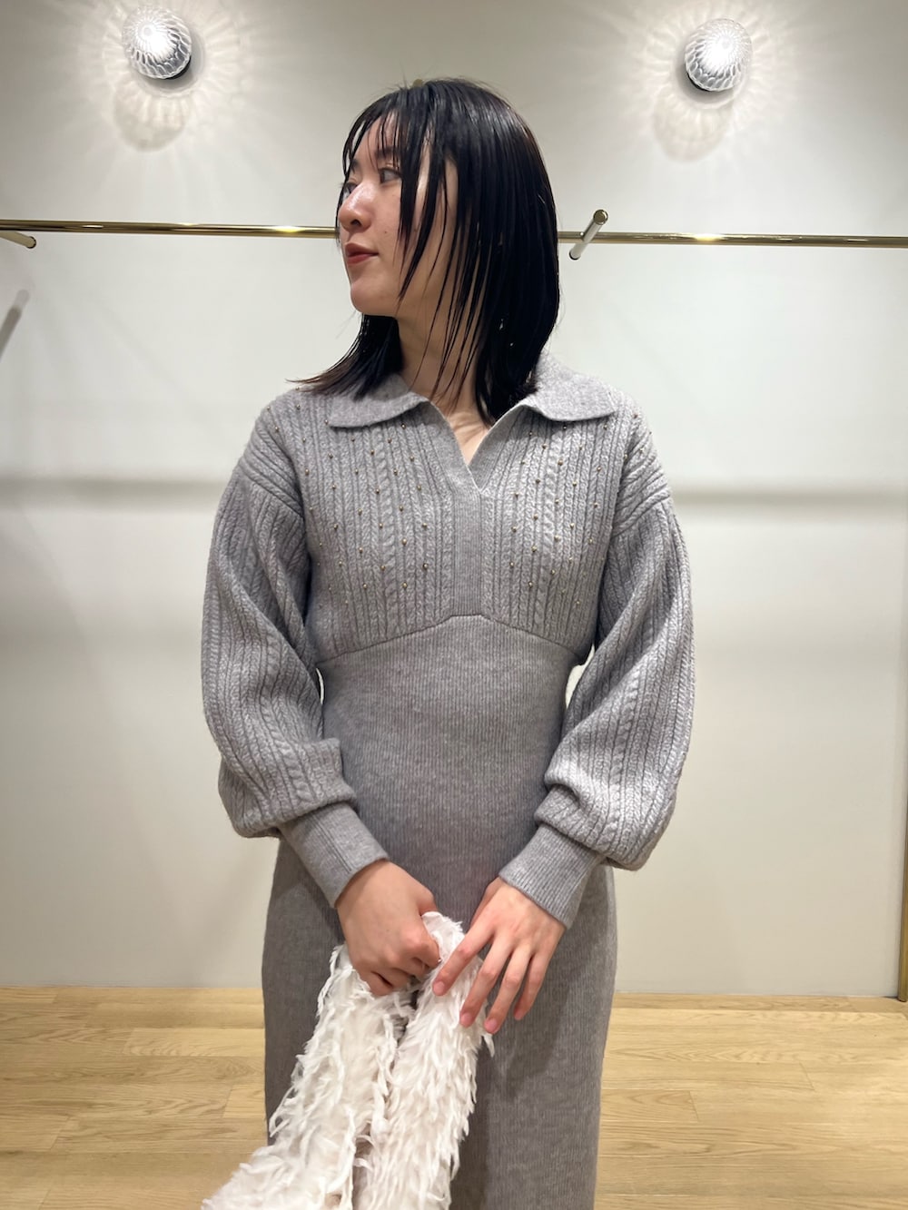 ホワイト系のハンドバッグ、グレー系のワンピースを着用したレディースの冬コーディネートの4枚目の写真