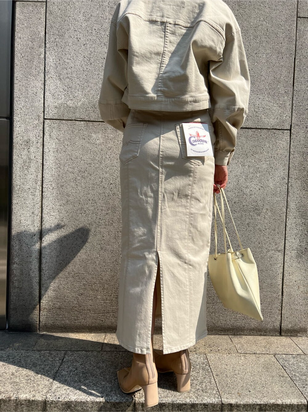 ホワイト系のハンドバッグ、ホワイト系のブルゾン、ホワイト系のスカートを着用したレディースの春コーディネートの5枚目の写真