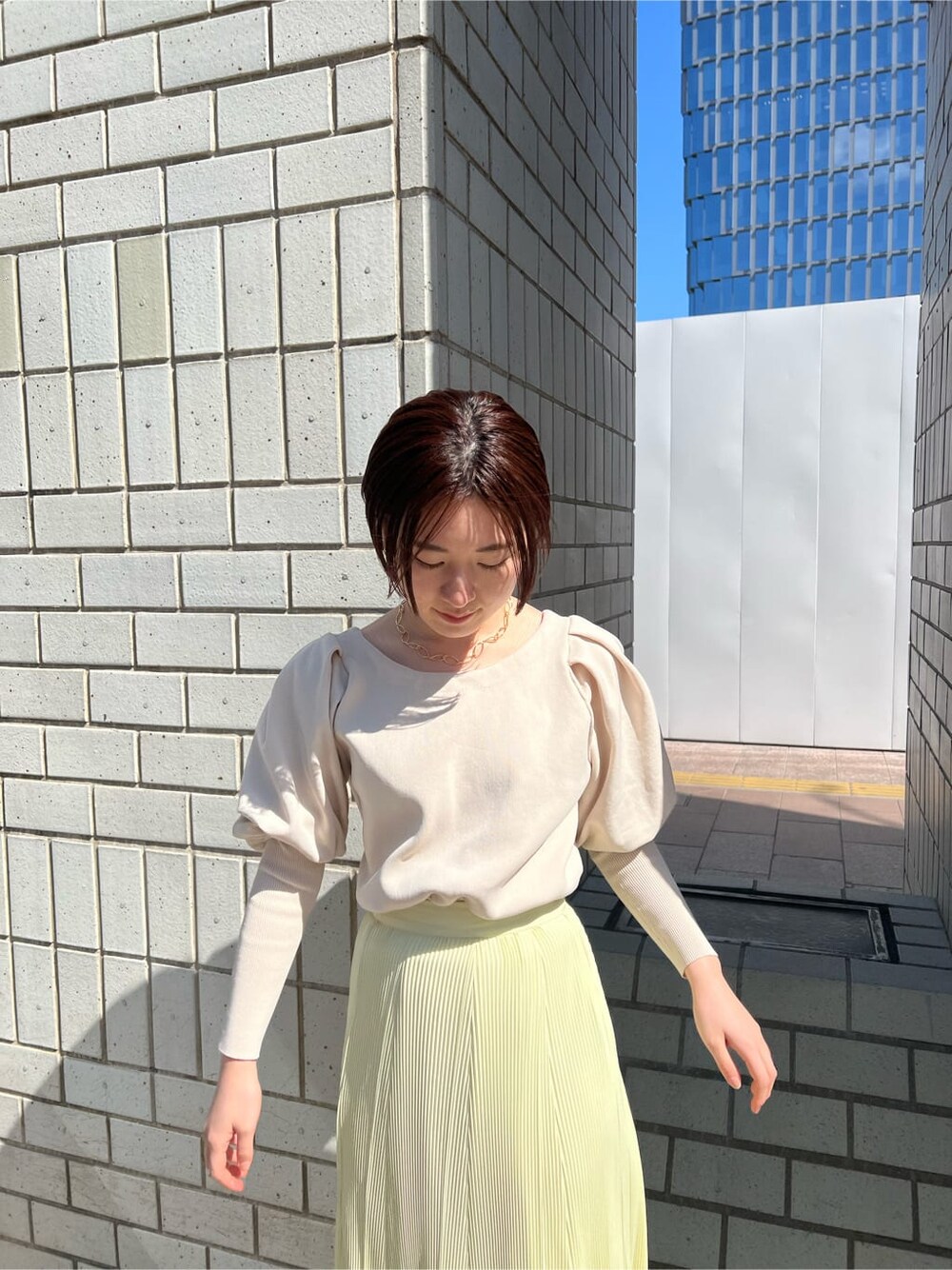 ブルー系のブルゾン、イエロー系のスカート、ベージュ系のニット/セーターを着用したレディースの春コーディネートの8枚目の写真