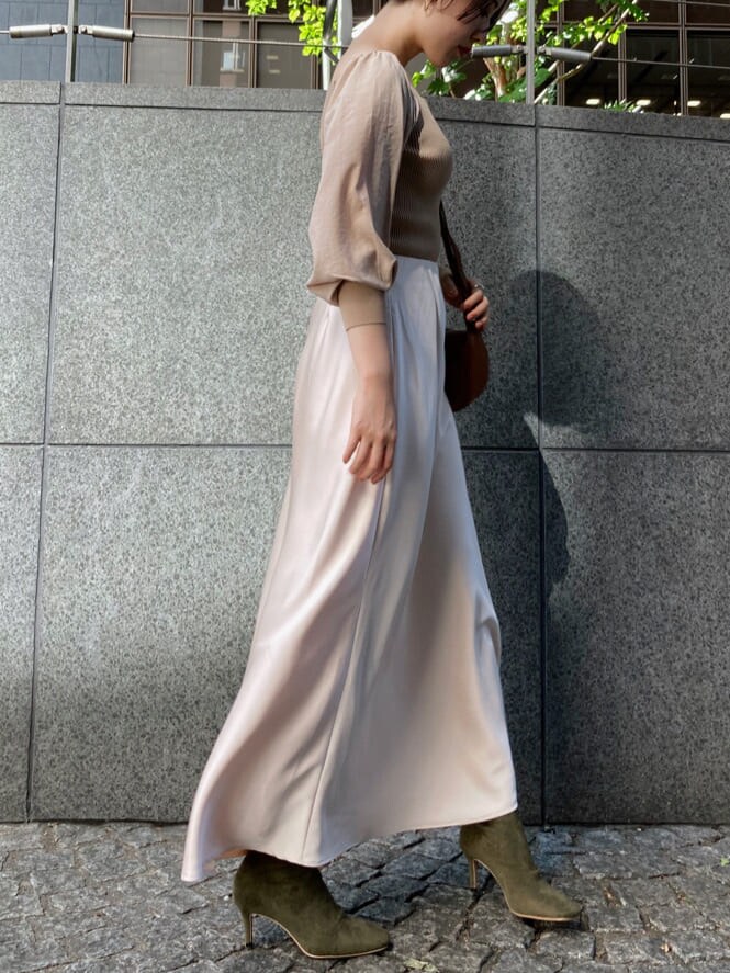 ホワイト系のスカート、ベージュ系のブーツ、ブラウン系のショルダーバッグを着用したレディースの秋コーディネートの2枚目の写真