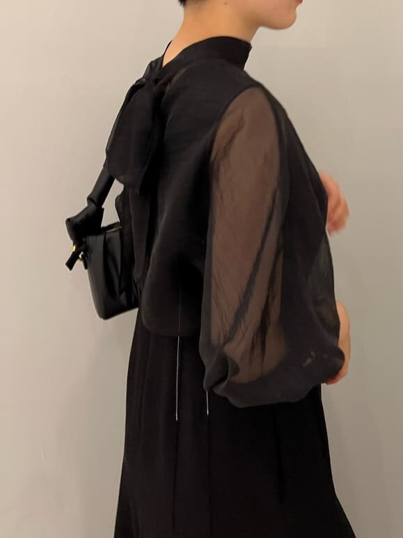 ベージュ系のブーツ、ブラック系のワンピース、ブラック系のハンドバッグを着用したレディースの秋コーディネートの5枚目の写真