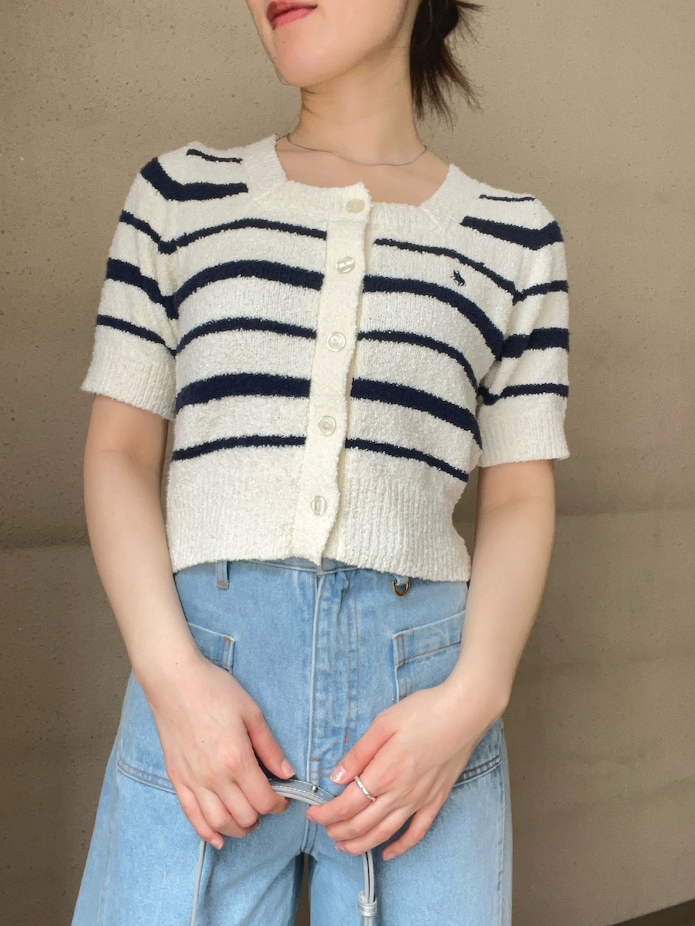 ブルー系のデニムパンツ、ホワイト系のニット/セーター、ブラック系のパンプスを着用したレディースの春コーディネートの4枚目の写真