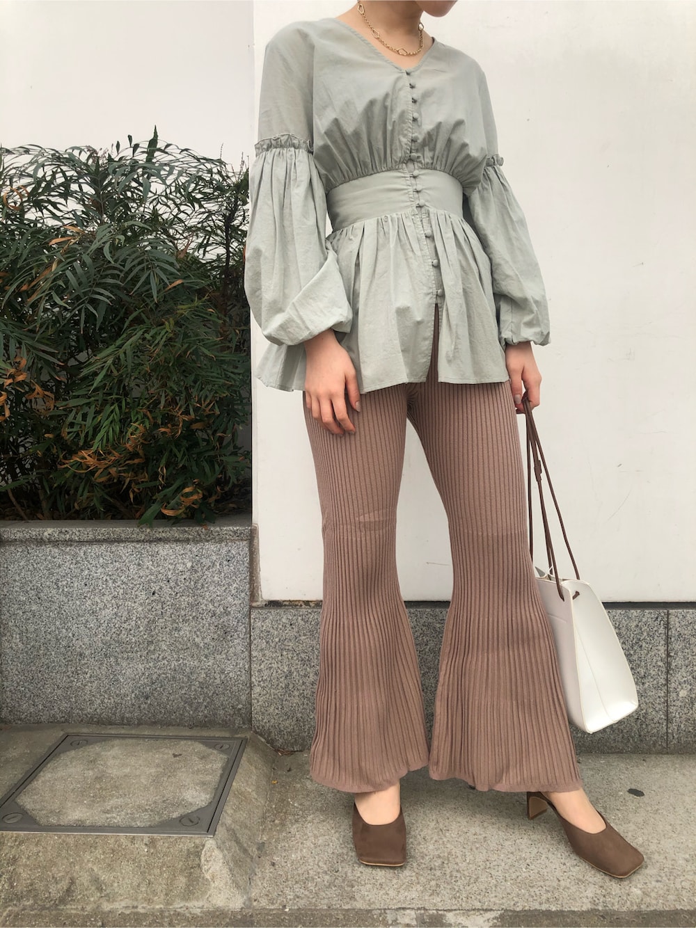 ベージュ系のその他パンツ、ベージュ系のサンダル、ホワイト系のハンドバッグを着用したレディースの春コーディネートの5枚目の写真