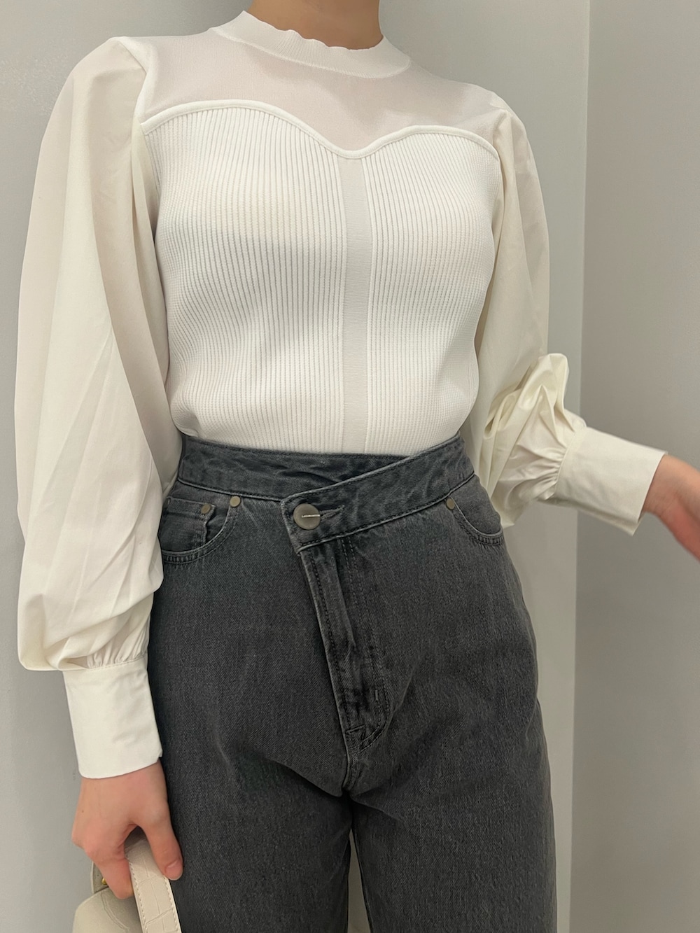 ホワイト系のトレンチコート、ホワイト系のニット/セーター、ブラック系のデニムパンツを着用したレディースの冬コーディネートの7枚目の写真