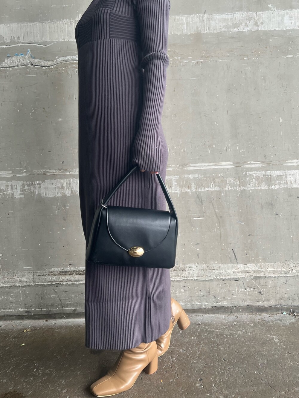 ブラック系のハンドバッグ、ベージュ系のブーツ、ホワイト系のカーディガン/ボレロを着用したレディースの冬コーディネートの9枚目の写真