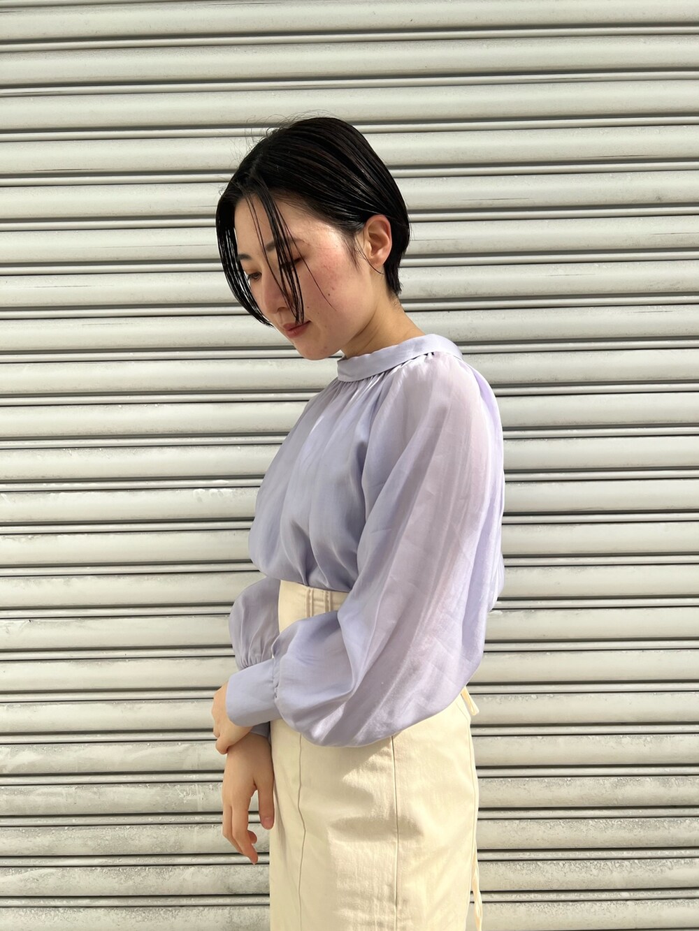 レッド系のブーツ、ホワイト系のスカート、ホワイト系のカーディガン/ボレロを着用したレディースの冬コーディネートの5枚目の写真