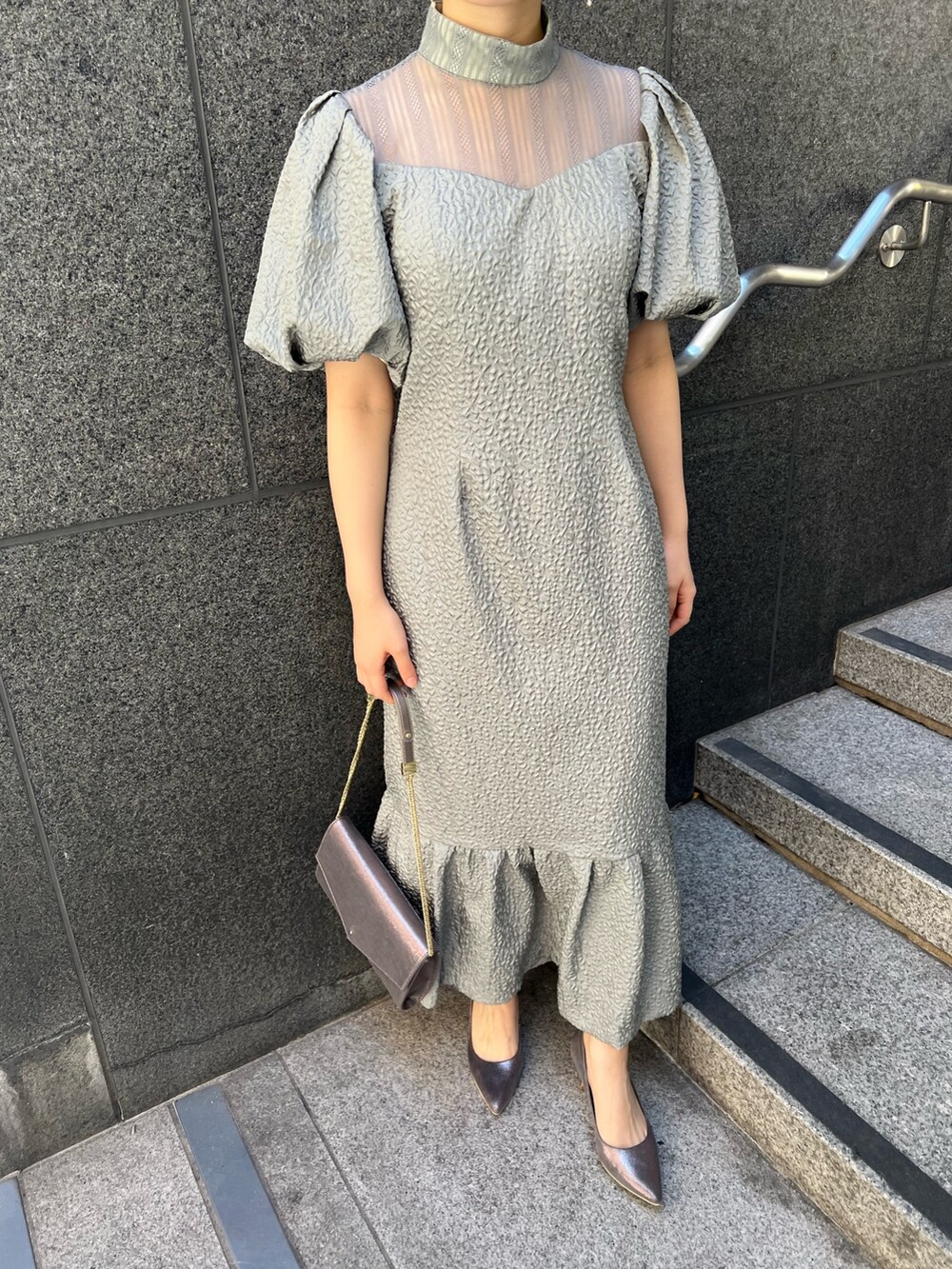 ブラック系のその他アウター、シルバー系のパンプス、グリーン系のドレスを着用したレディースの秋コーディネートの10枚目の写真