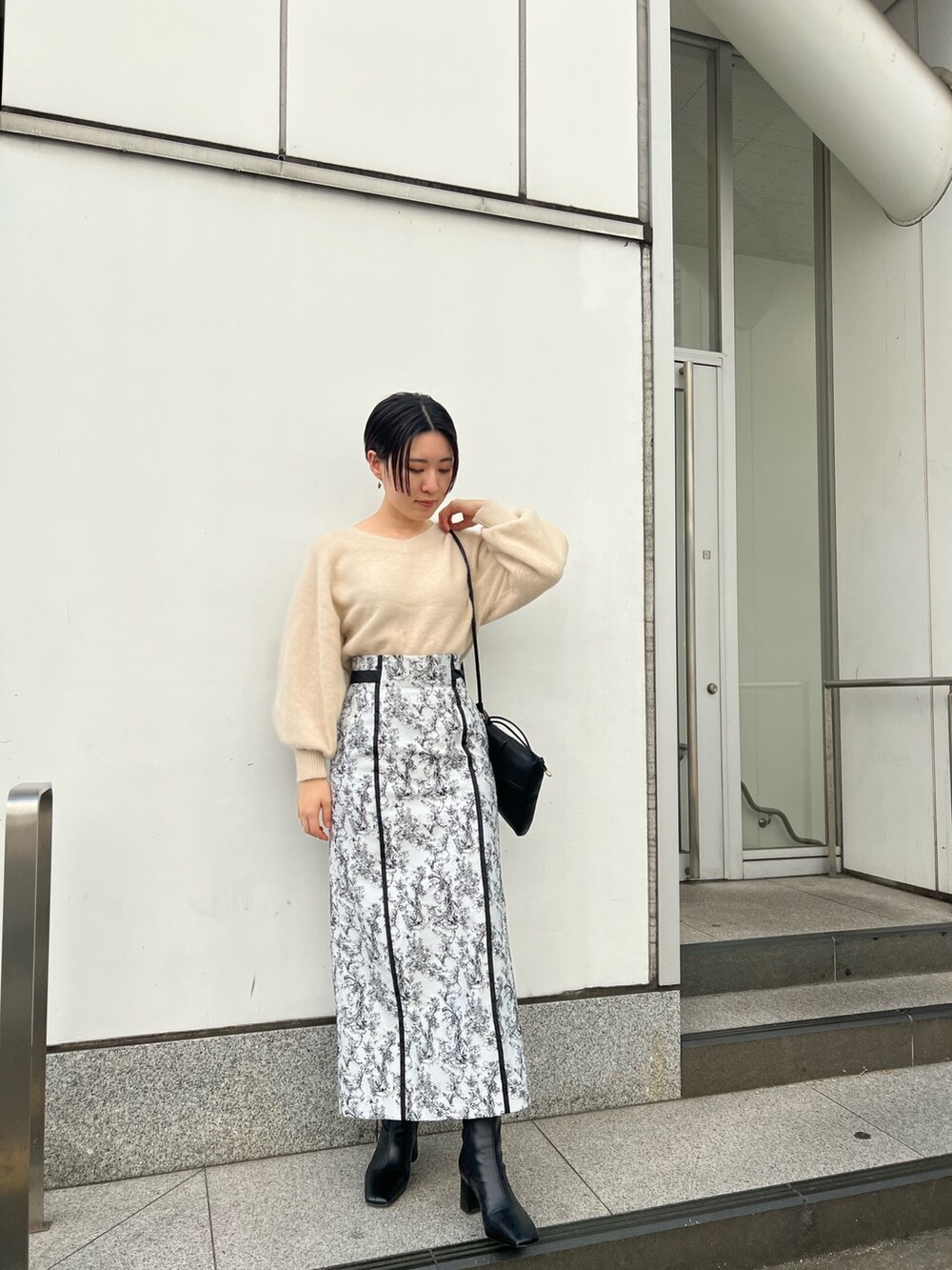 ブラック系のブーツ、ブラック系のスカート、グレー系のカーディガン/ボレロを着用したレディースの秋コーディネートの5枚目の写真