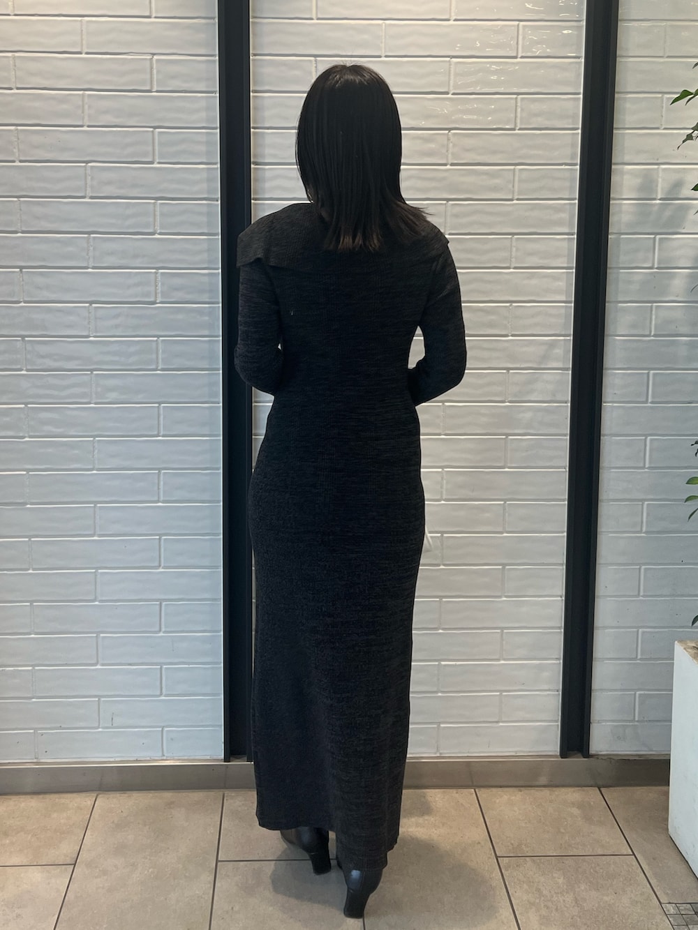 ホワイト系のダウンジャケット/コート、ブラック系のワンピース、ブラック系のブーツを着用したレディースの冬コーディネートの7枚目の写真