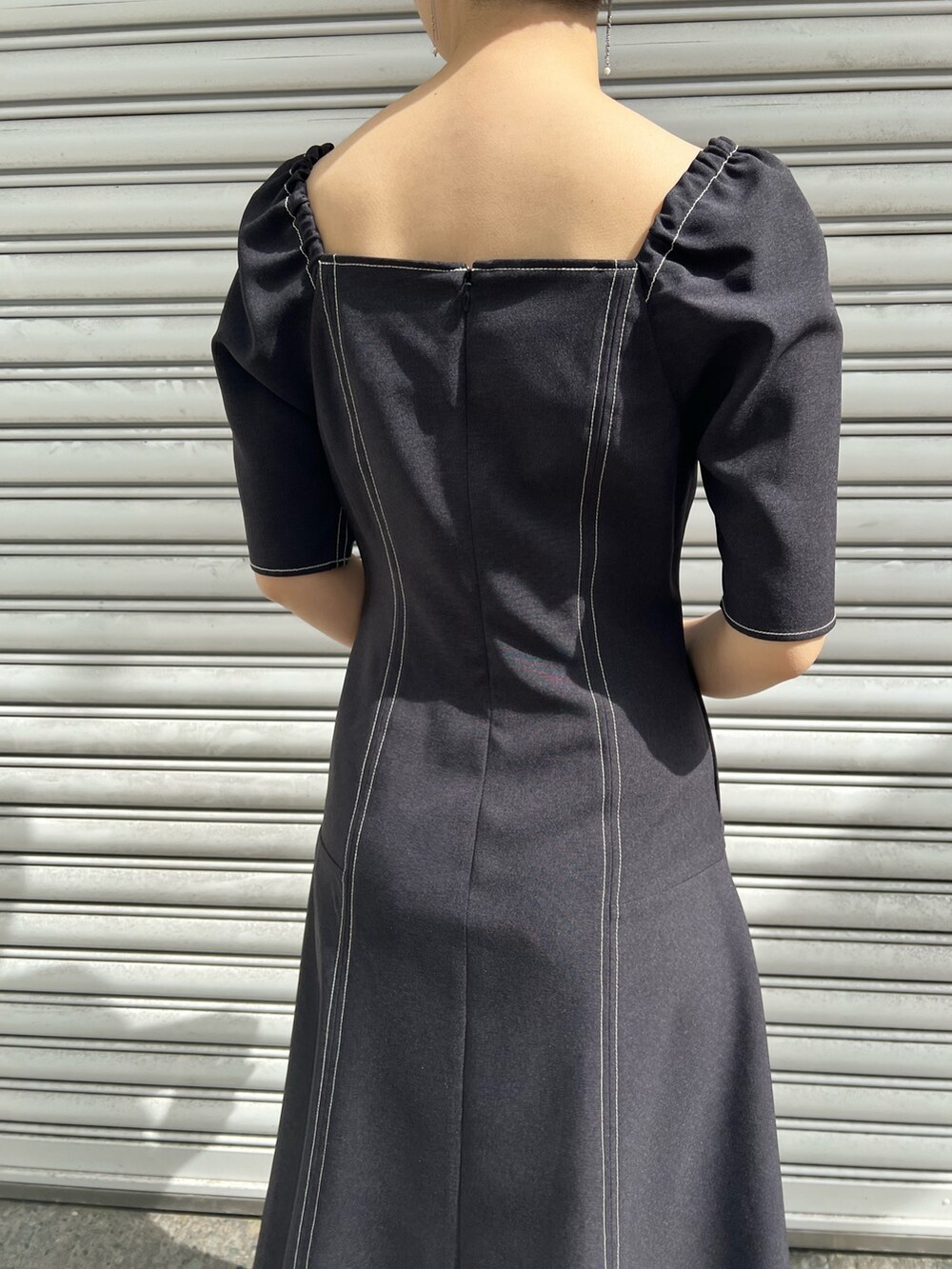 ベージュ系のサンダル、ブラック系のワンピース、ベージュ系のテーラードジャケットを着用したレディースの春コーディネートの6枚目の写真