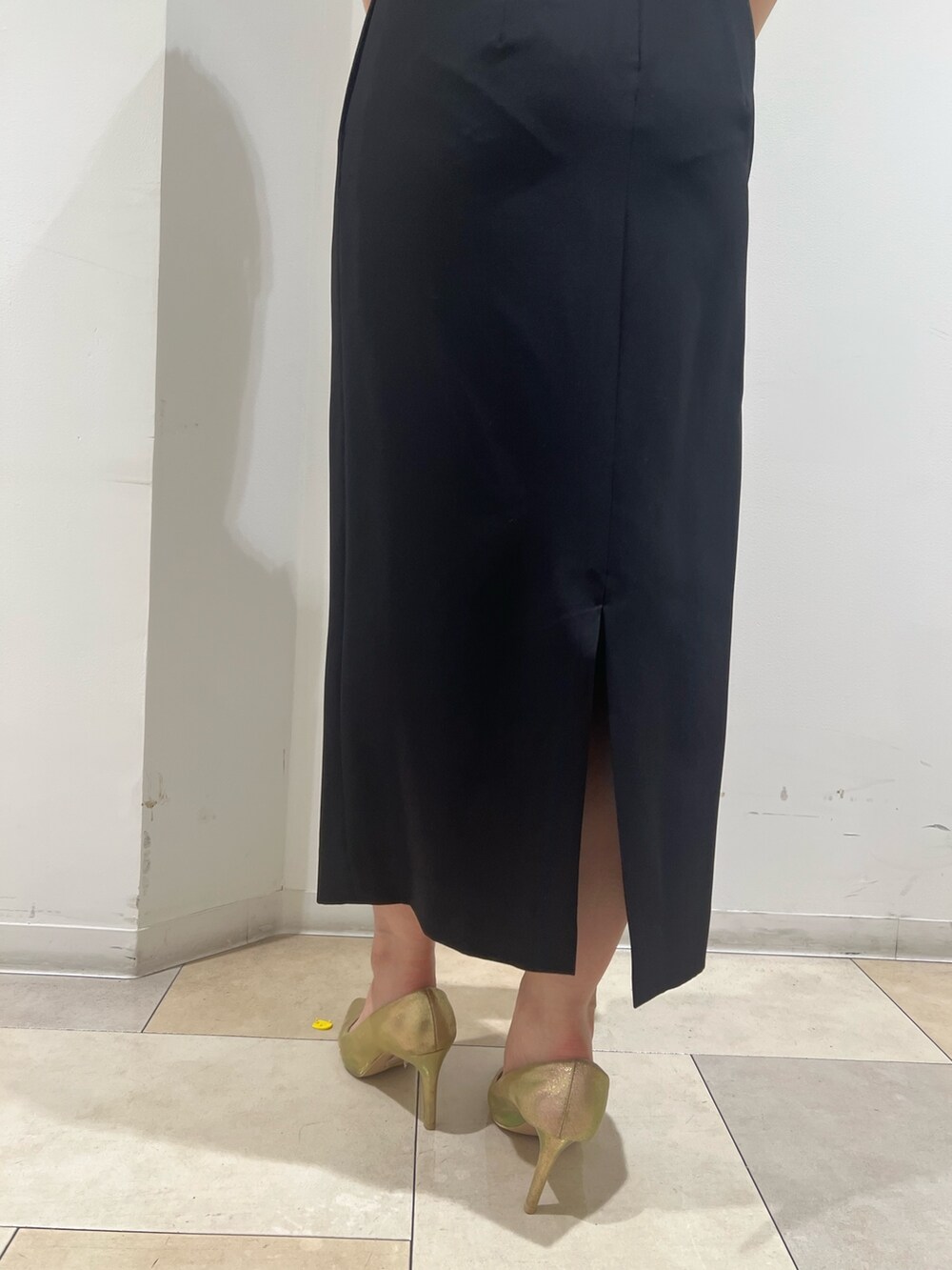 ゴールド系のパンプス、ゴールド系のハンドバッグ、ブラック系のドレスを着用したレディースの夏コーディネートの8枚目の写真