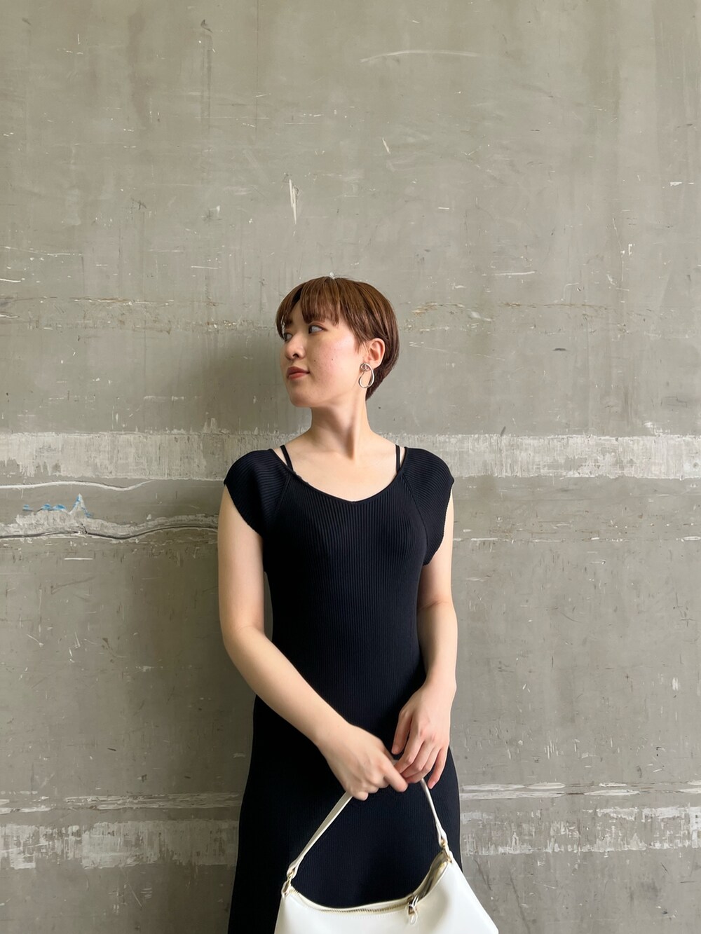 ブラック系のワンピース、ホワイト系のハンドバッグ、ベージュ系のサンダルを着用したレディースの夏コーディネートの4枚目の写真