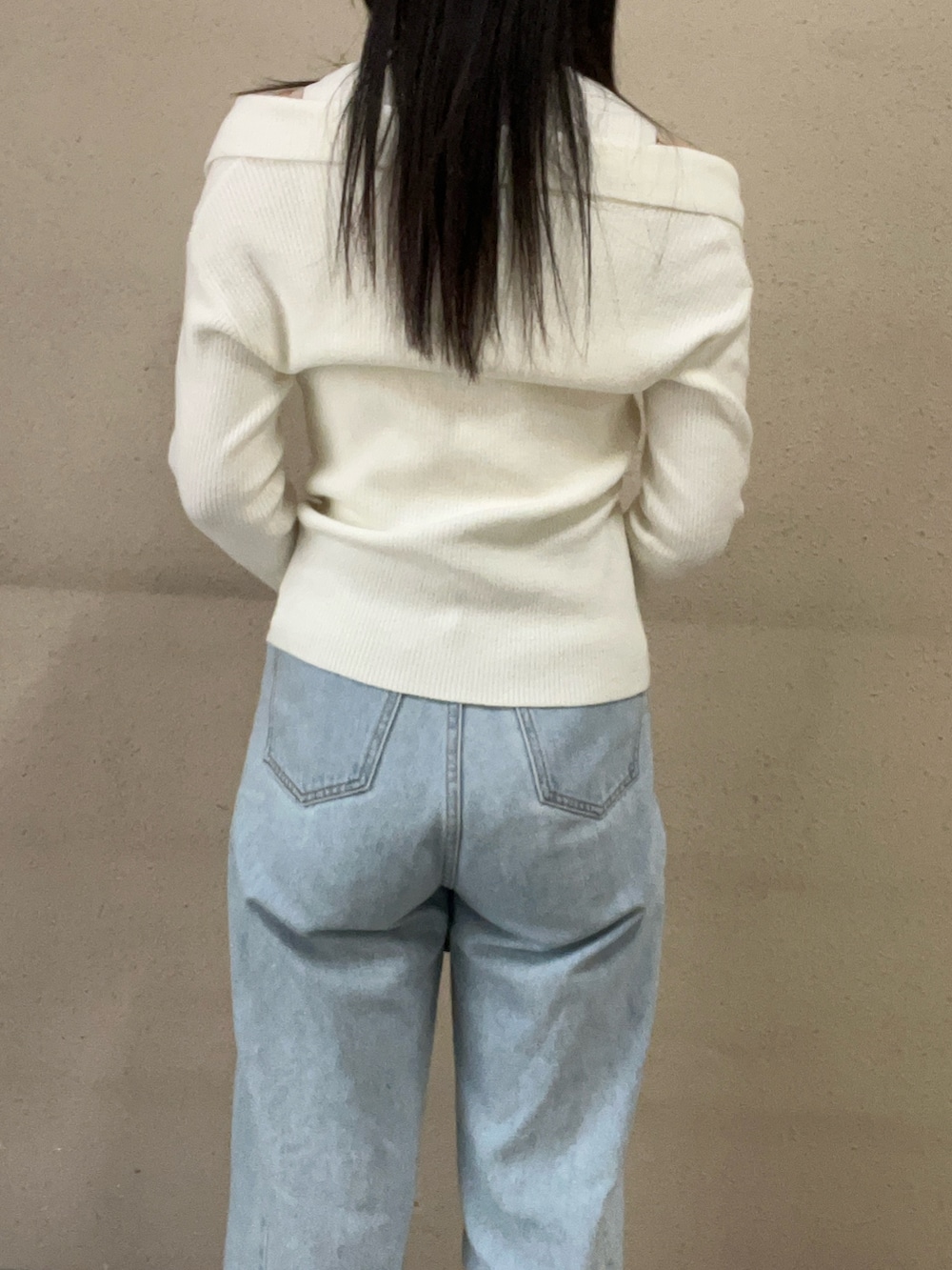 ホワイト系のアンサンブル、ブルー系のデニムパンツを着用したレディースの冬コーディネートの6枚目の写真