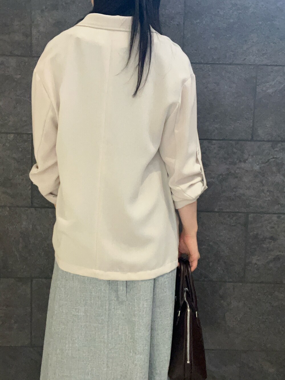 ベージュ系のテーラードジャケット、ブルー系のワンピース、ブラウン系のパンプスを着用したレディースの夏コーディネートの6枚目の写真