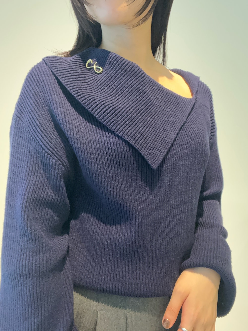 イエロー系のハンドバッグ、ブルー系のニット/セーター、ブラウン系のパンプスを着用したレディースの秋コーディネートの5枚目の写真