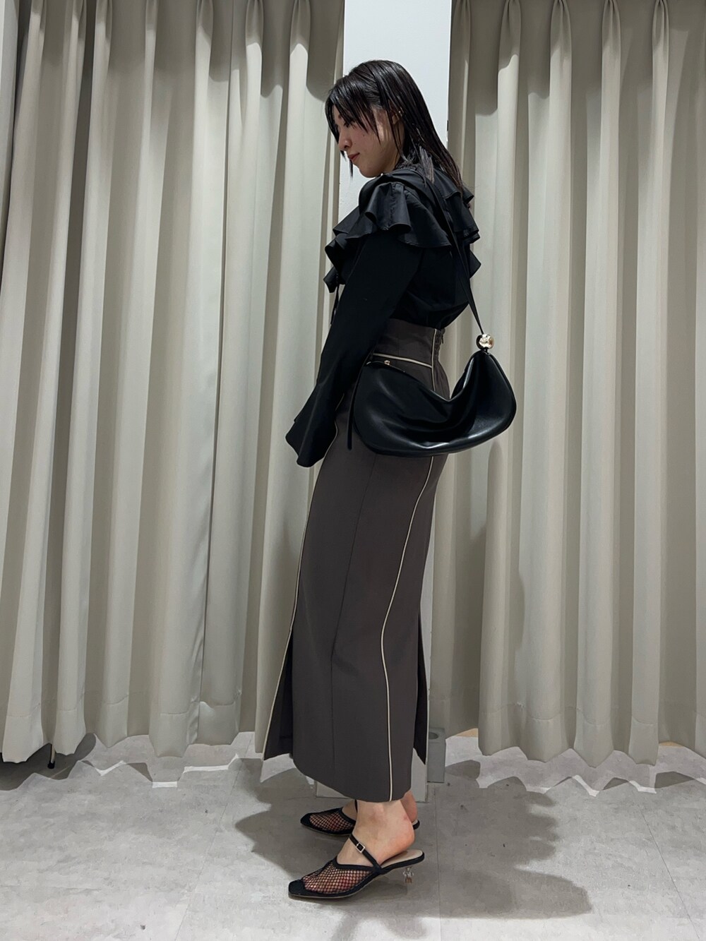 ホワイト系のシャツ/ブラウス、グレー系のスカート、ブラック系のショルダーバッグを着用したレディースの春コーディネートの2枚目の写真