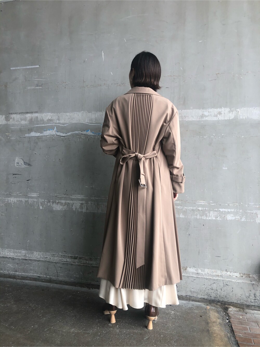 ホワイト系のスカート、ブラウン系のパンプス、ベージュ系のその他アウターを着用したレディースの春コーディネートの3枚目の写真