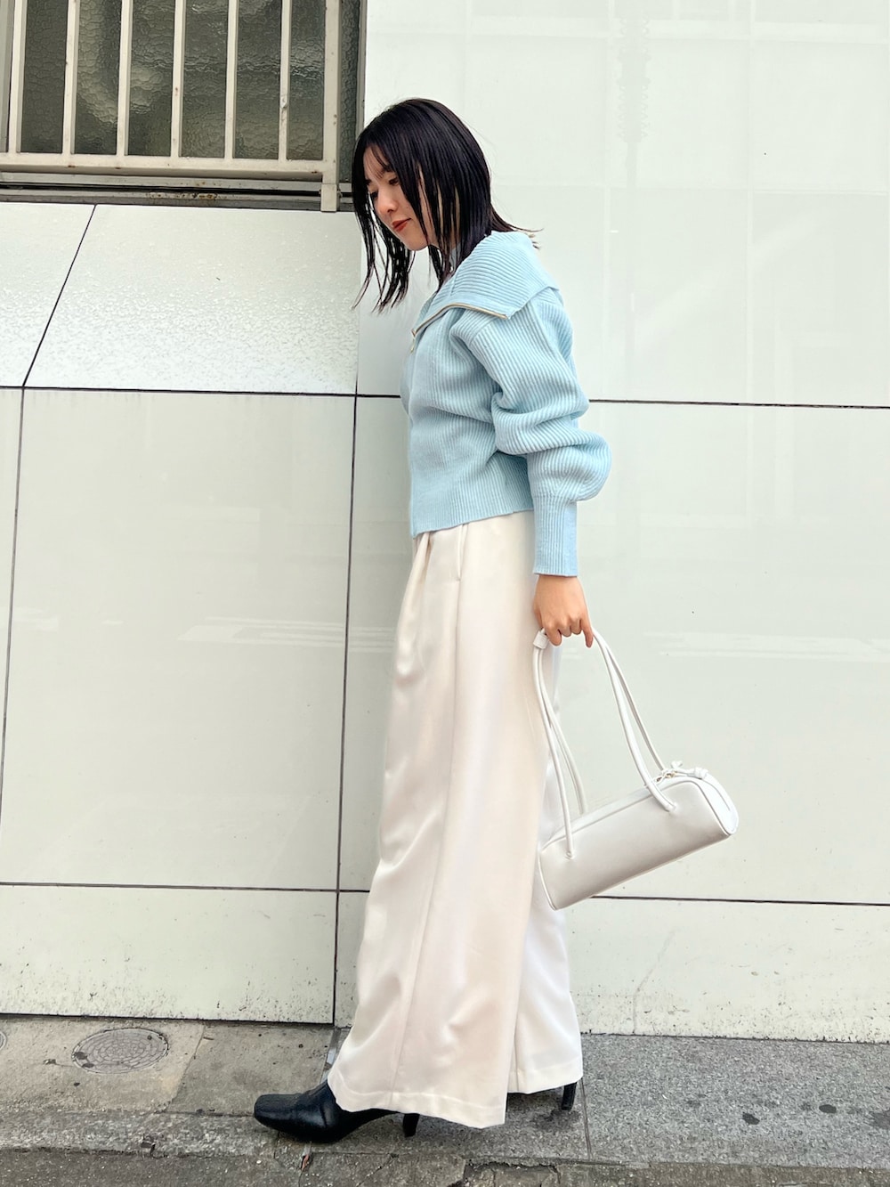 ホワイト系のショルダーバッグ、ホワイト系のその他パンツ、ブルー系のニット/セーターを着用したレディースの秋コーディネートの2枚目の写真