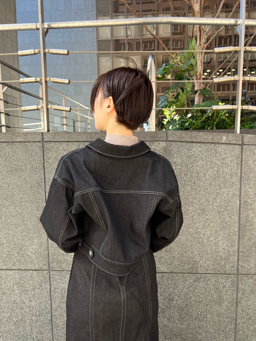 ブラック系のデニムスカート、ベージュ系のショルダーバッグ、レッド系のブーツを着用したレディースの冬コーディネートの3枚目の写真