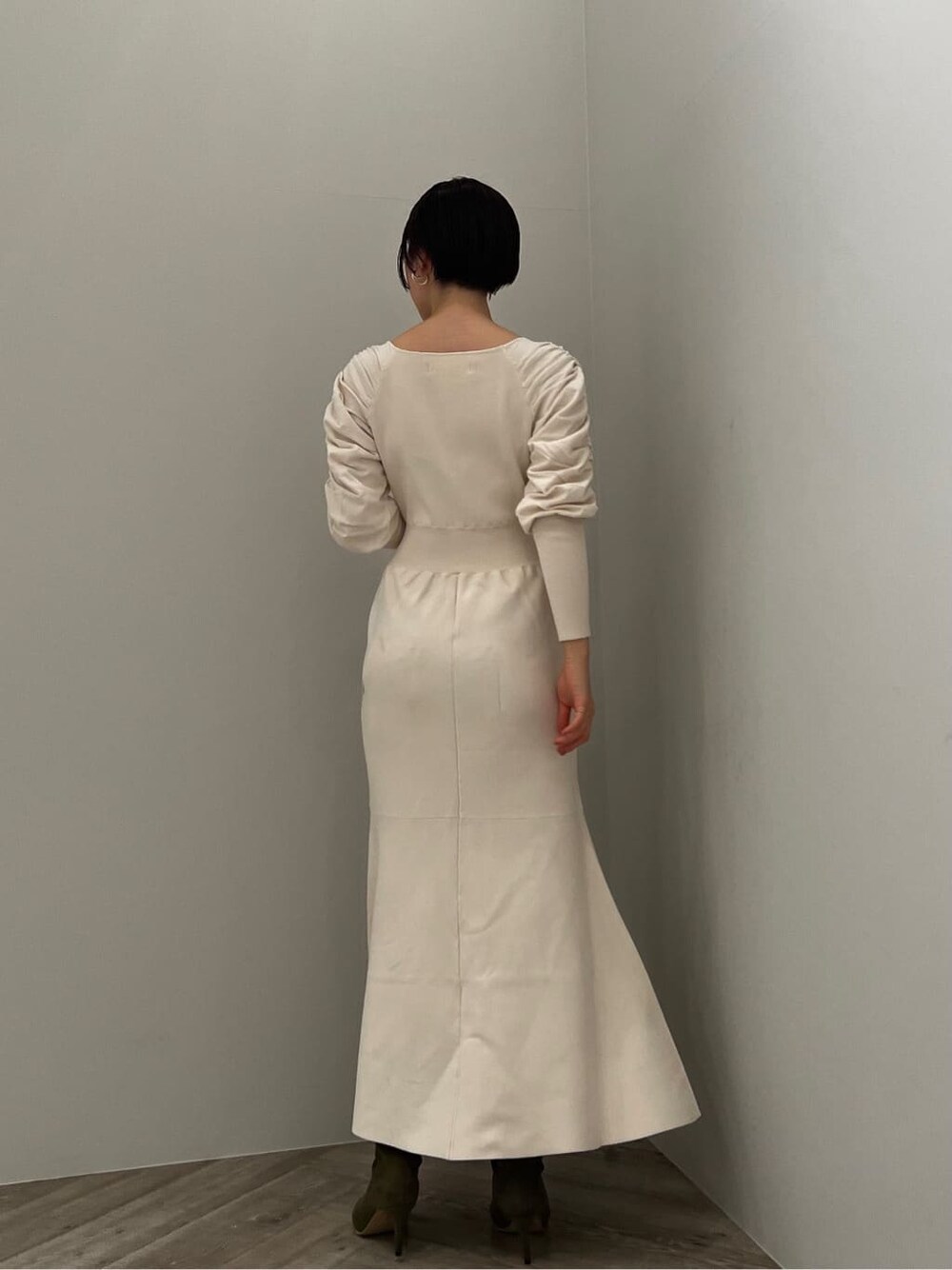 ベージュ系のブーツ、ホワイト系のワンピースを着用したレディースの冬コーディネートの2枚目の写真