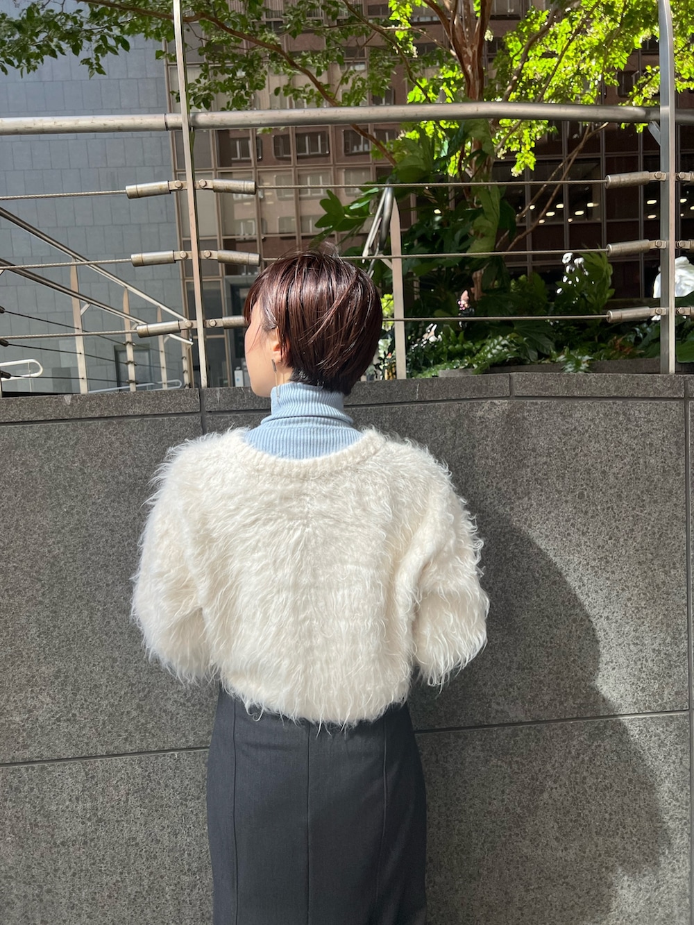 ホワイト系のブーツ、ホワイト系のカーディガン/ボレロ、ブルー系のニット/セーターを着用したレディースの秋コーディネートの4枚目の写真