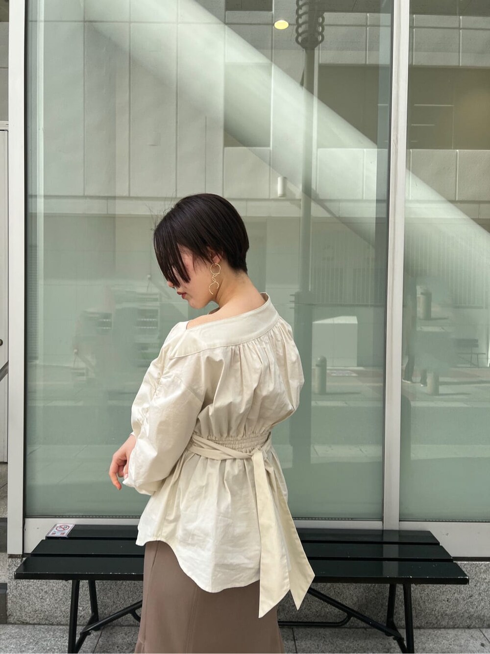 ベージュ系のスカート、ホワイト系のシャツ/ブラウス、ホワイト系のパンプスを着用したレディースの冬コーディネートの8枚目の写真