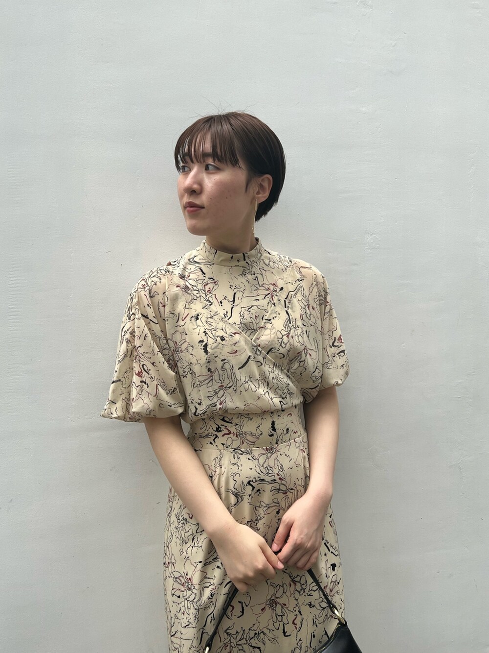 ブラック系のハンドバッグ、その他のサンダル、ベージュ系のワンピースを着用したレディースの夏コーディネートの6枚目の写真