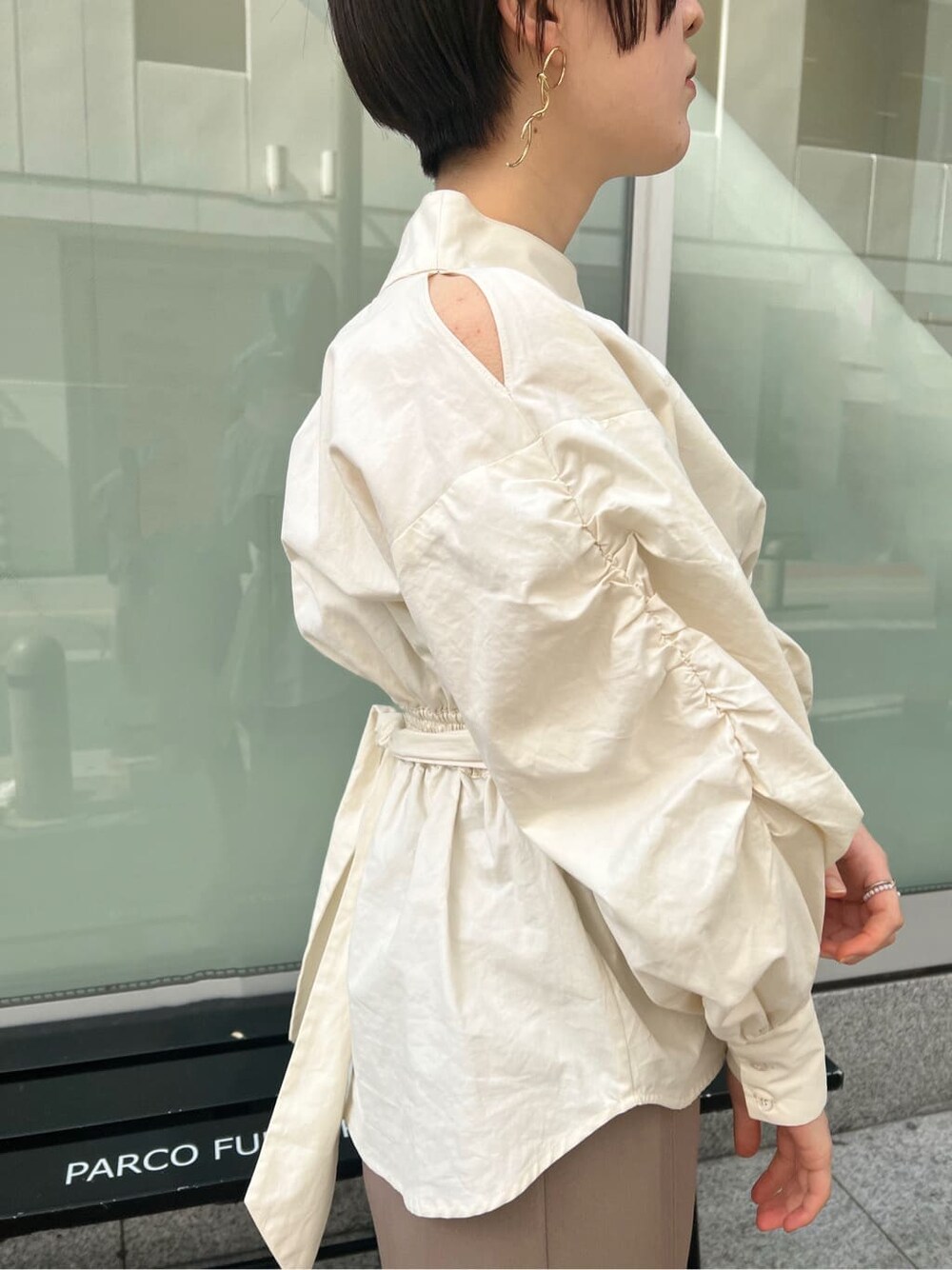 ベージュ系のスカート、ホワイト系のシャツ/ブラウス、ホワイト系のパンプスを着用したレディースの冬コーディネートの3枚目の写真