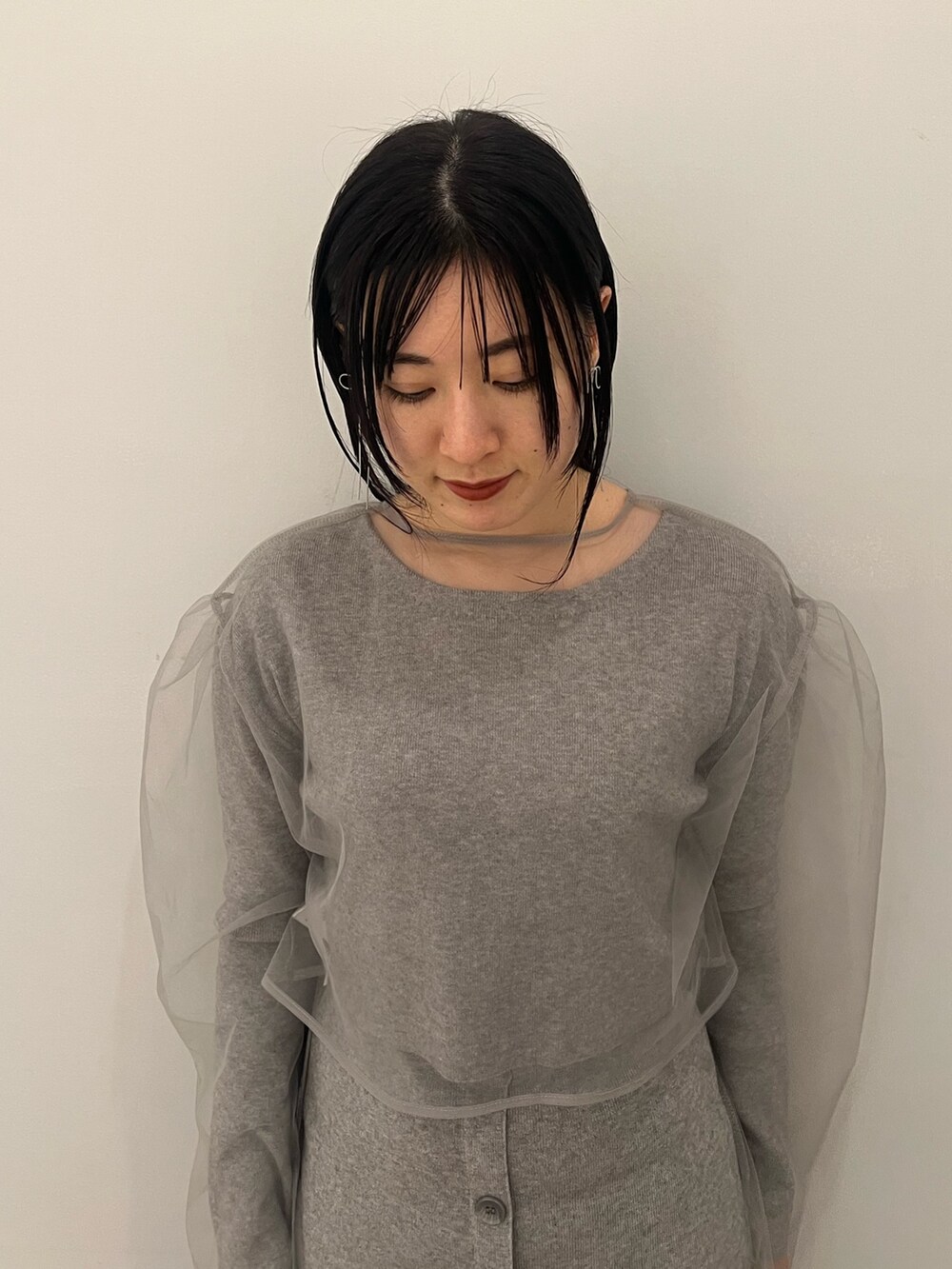 グレー系のワンピース、ブラック系のブーツ、ブラック系のショルダーバッグを着用したレディースの冬コーディネートの4枚目の写真