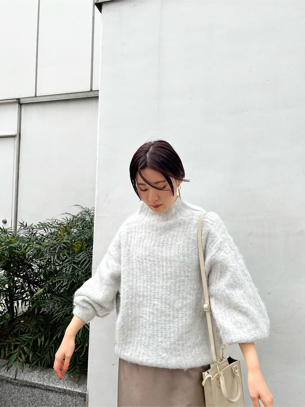 ベージュ系のスカート、ホワイト系のショルダーバッグ、ベージュ系のその他シューズを着用したレディースの冬コーディネートの5枚目の写真