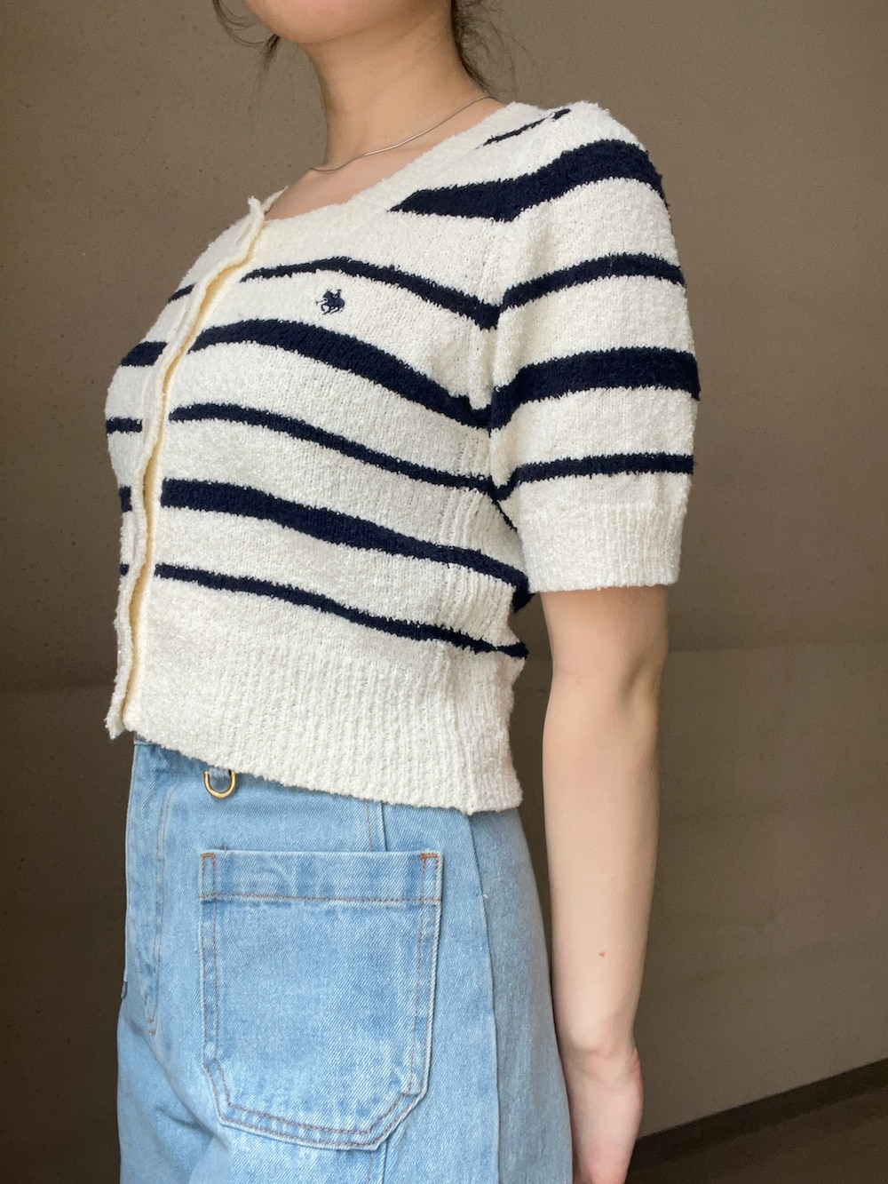 ブルー系のデニムパンツ、ホワイト系のニット/セーター、ブラック系のパンプスを着用したレディースの春コーディネートの5枚目の写真