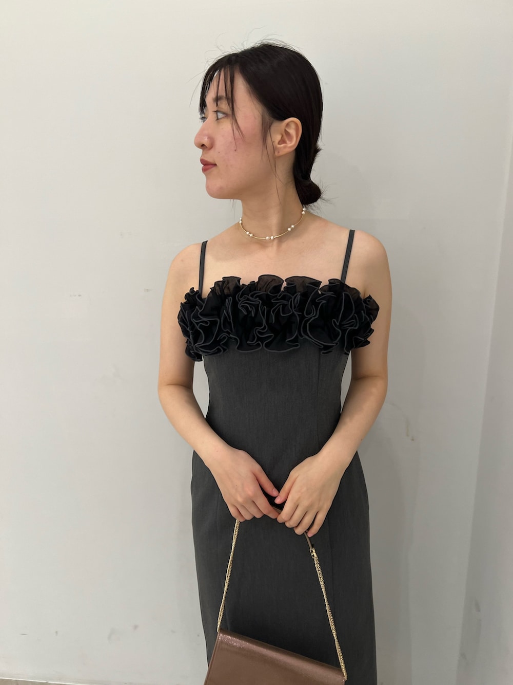 ゴールド系のパンプス、グレー系のドレス、ベージュ系のテーラードジャケットを着用したレディースの秋コーディネートの5枚目の写真