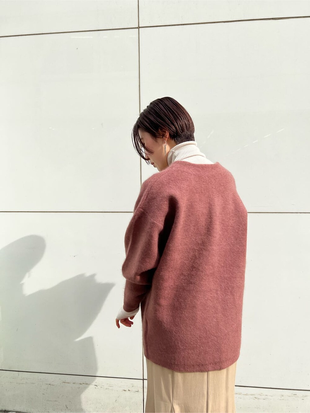 ベージュ系のスカート、ホワイト系のその他シューズ、ピンク系のカーディガン/ボレロを着用したレディースの冬コーディネートの4枚目の写真