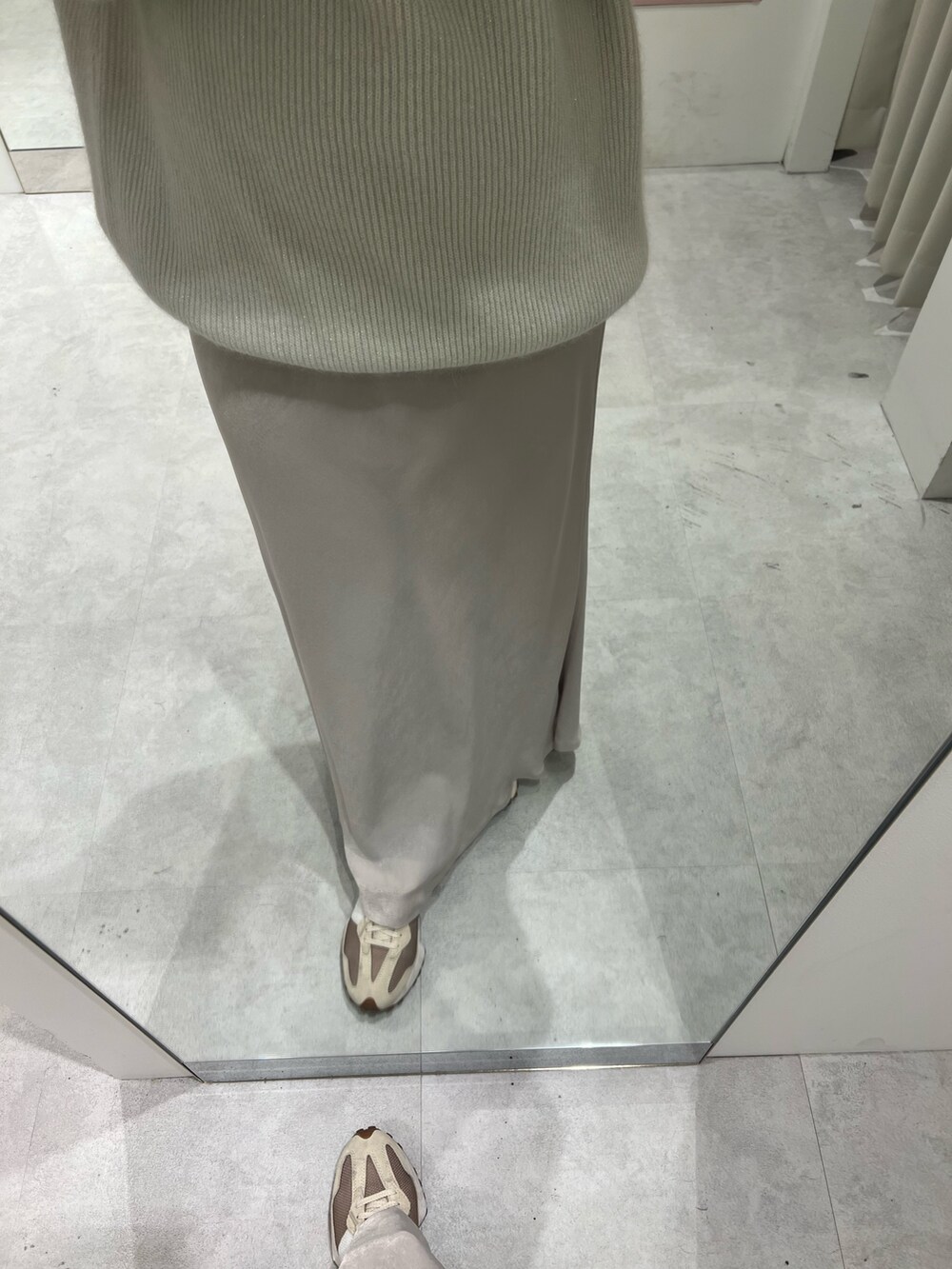 ベージュ系のスニーカー、ホワイト系のニット/セーター、ホワイト系のスカートを着用したレディースの秋コーディネートの8枚目の写真