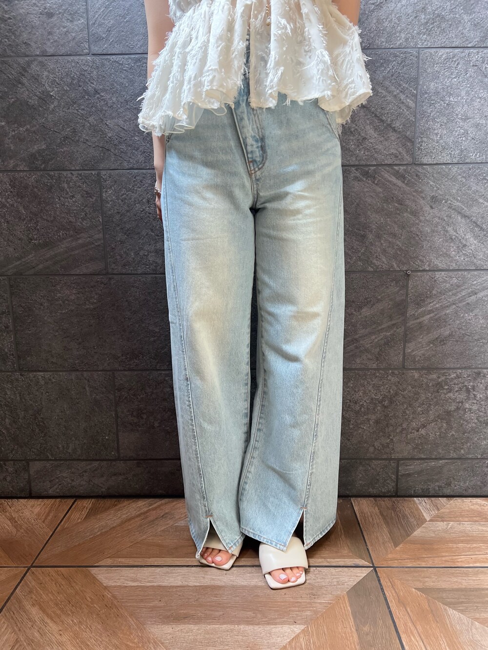 ホワイト系のサンダル、ホワイト系のキャミソール、ブルー系のデニムパンツを着用したレディースの夏コーディネートの5枚目の写真