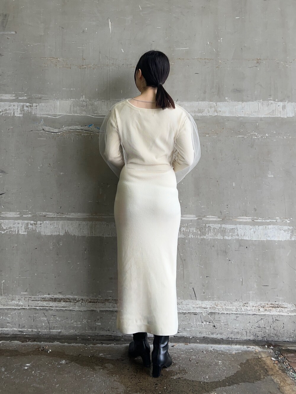 ホワイト系のブルゾン、ホワイト系のワンピース、ブラック系のブーツを着用したレディースの冬コーディネートの4枚目の写真