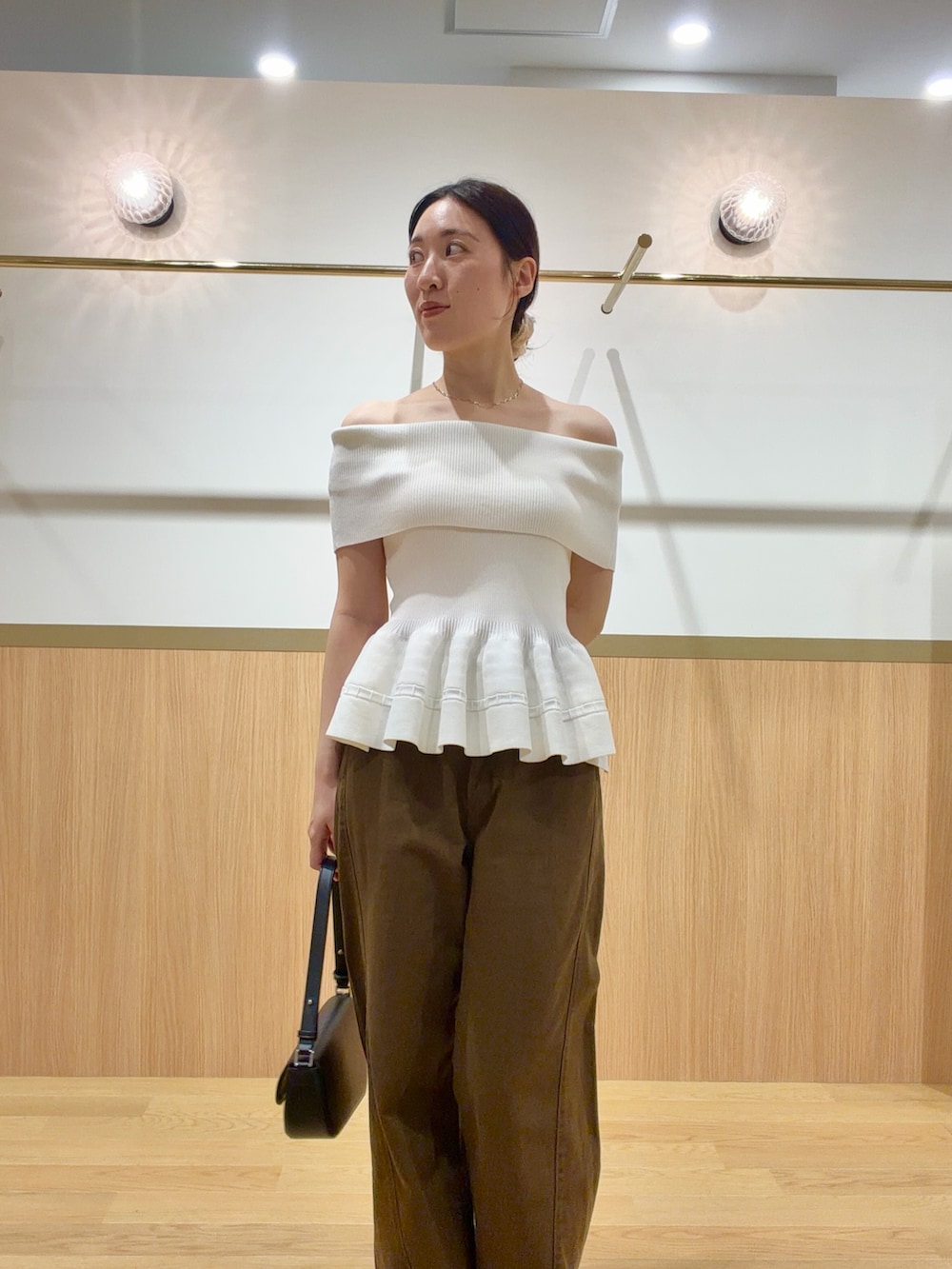 ブラウン系のデニムパンツ、ホワイト系のニット/セーター、ブラウン系のサンダルを着用したレディースの夏コーディネートの4枚目の写真