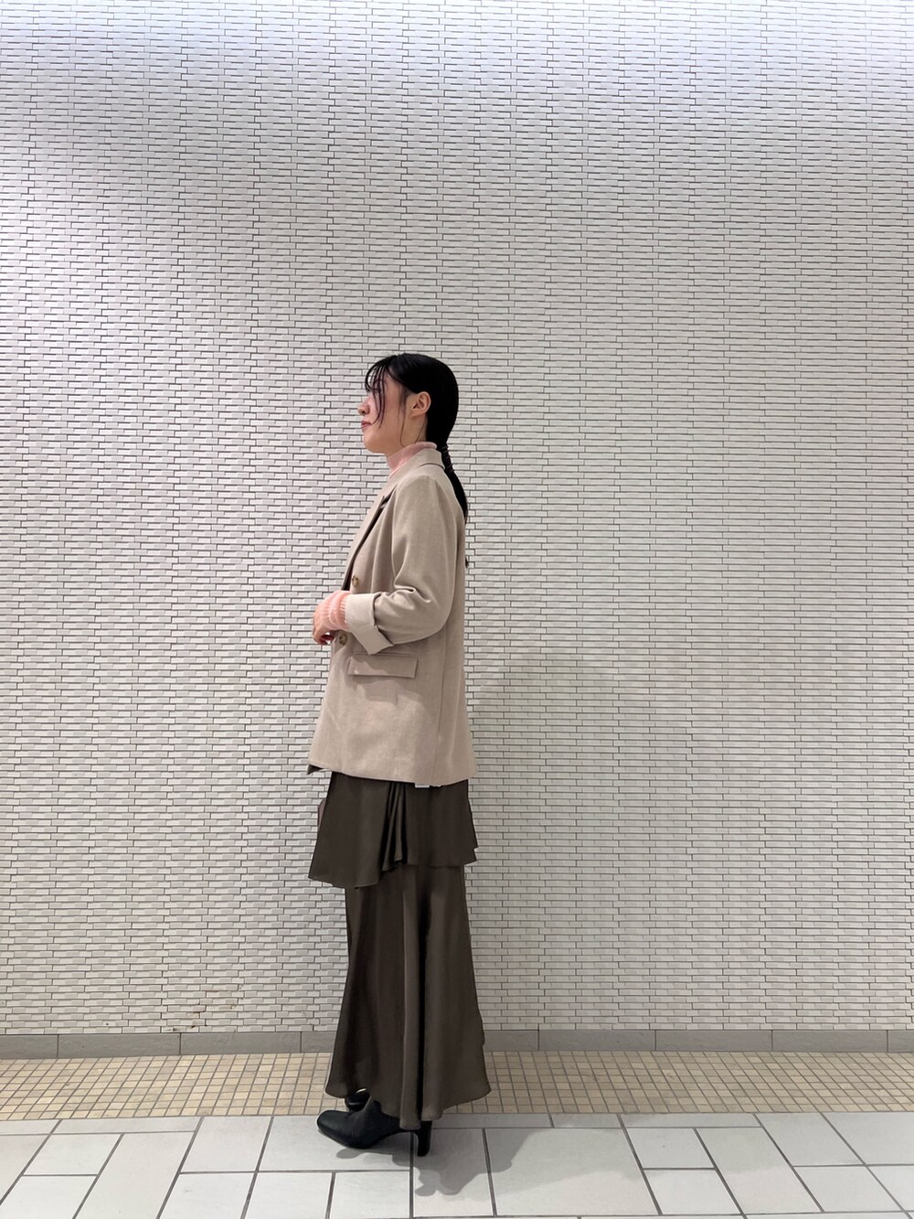 ピンク系のニット/セーター、ブラック系のブーツ、ベージュ系のテーラードジャケットを着用したレディースの秋コーディネートの2枚目の写真