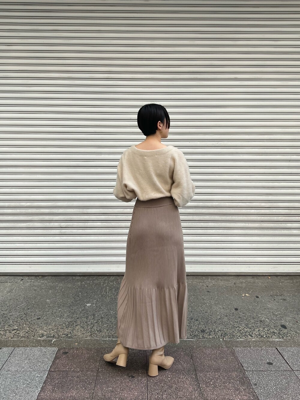 ピンク系のノーカラーコート、ホワイト系のワンピース、ベージュ系のブーツを着用したレディースの秋コーディネートの6枚目の写真