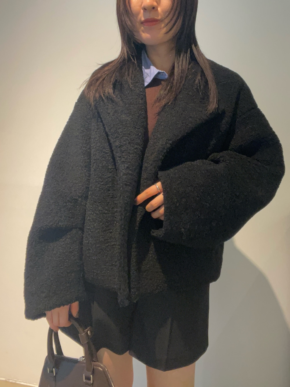 ブラウン系のブーツ、ブラック系のブルゾン、ブラウン系のニット/セーターを着用したレディースの秋コーディネートの4枚目の写真