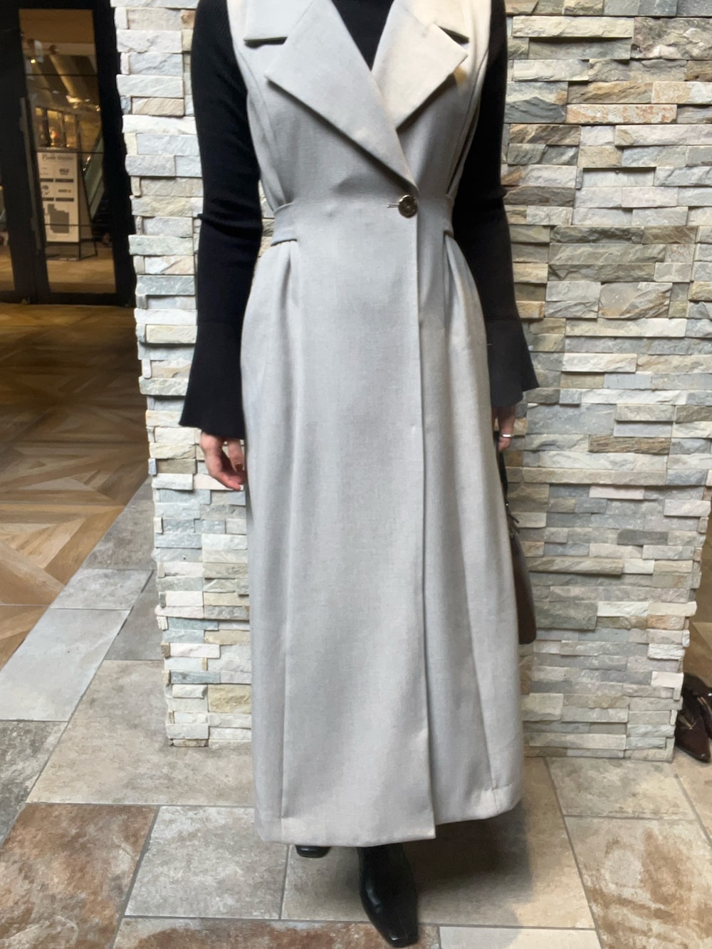 ブラック系のブーツ、ブラック系のニット/セーター、グレー系のワンピースを着用したレディースの秋コーディネートの4枚目の写真