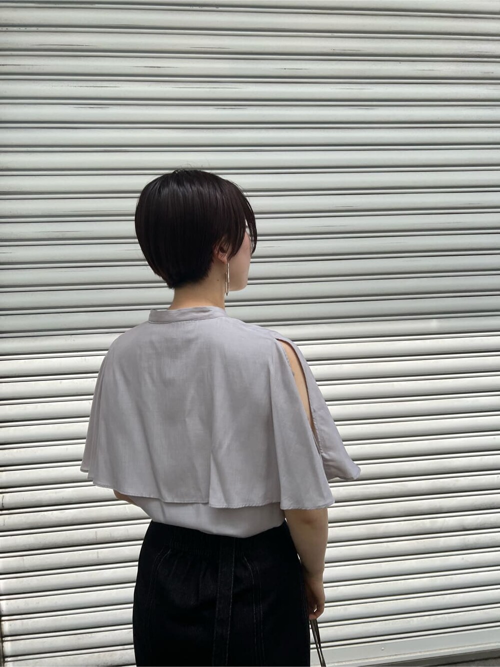 ベージュ系のハンドバッグ、ブラック系のスカート、その他のサンダルを着用したレディースの夏コーディネートの5枚目の写真