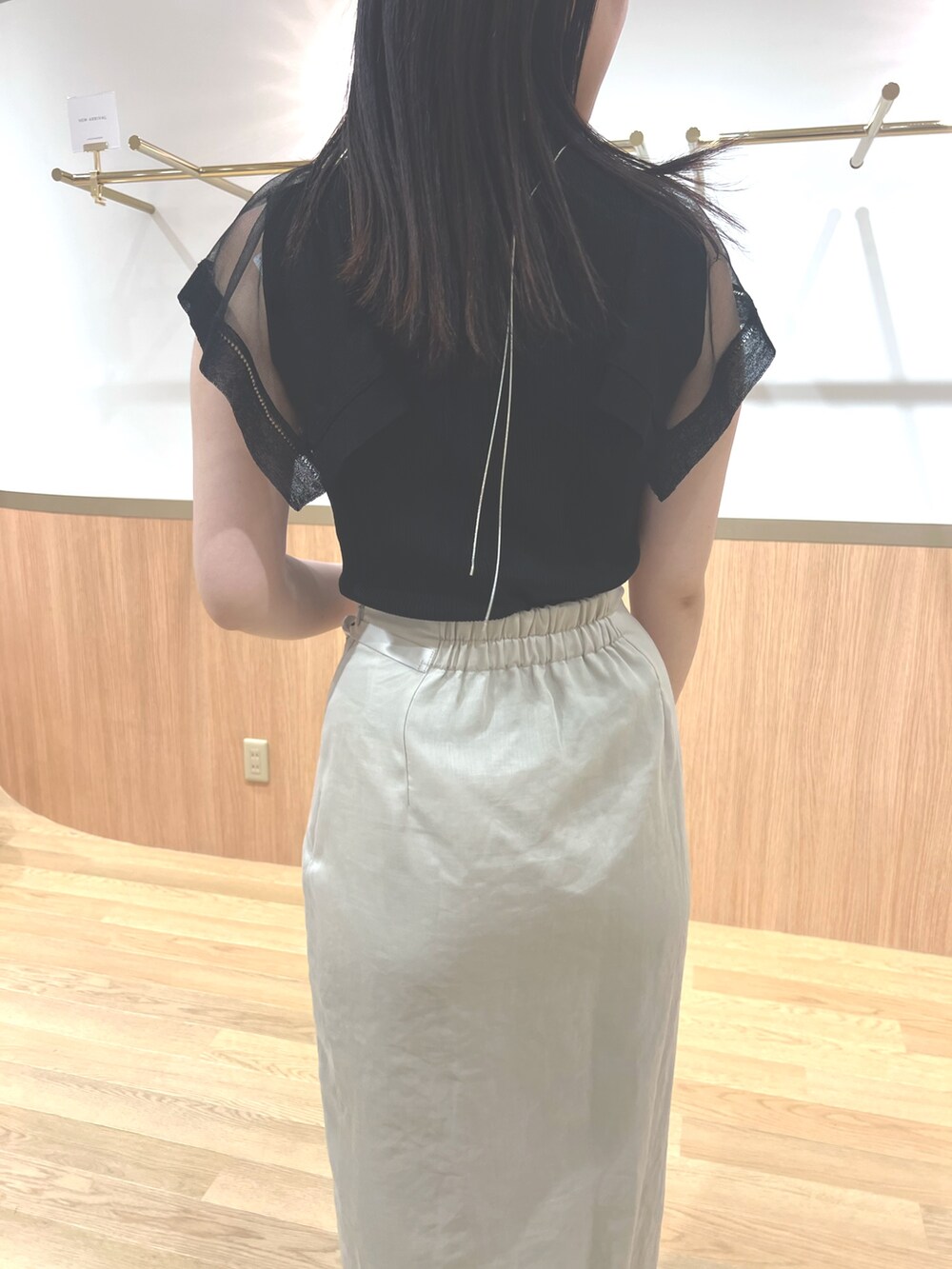 ブラック系のニット/セーター、ホワイト系のスカート、ホワイト系のサンダルを着用したレディースの春コーディネートの6枚目の写真