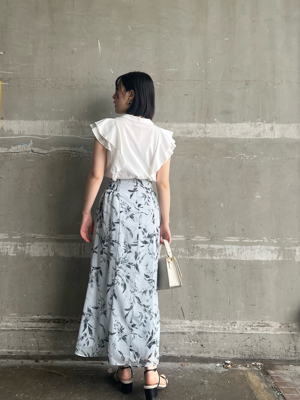 ホワイト系のシャツ/ブラウス、ブラック系のサンダル、ホワイト系のショルダーバッグを着用したレディースの春コーディネートの2枚目の写真