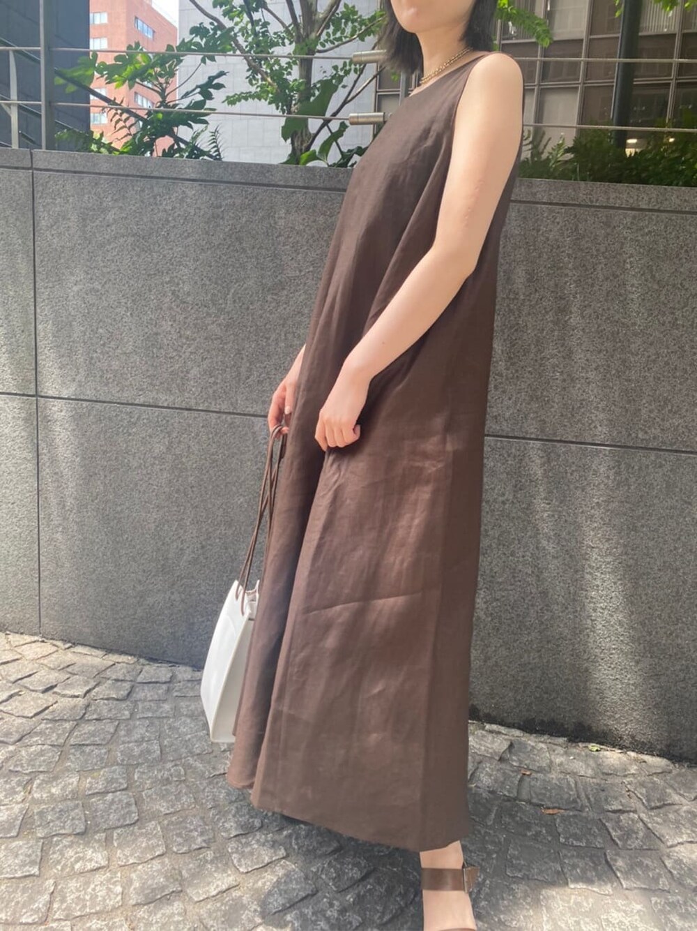 ホワイト系のハンドバッグ、ブラウン系のサンダル、ブラウン系のワンピースを着用したレディースの夏コーディネートの4枚目の写真