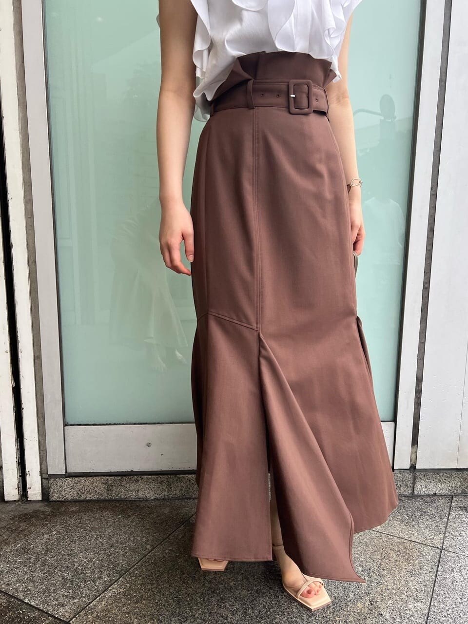ベージュ系のハンドバッグ、ブラウン系のスカート、ベージュ系のサンダルを着用したレディースの春コーディネートの5枚目の写真