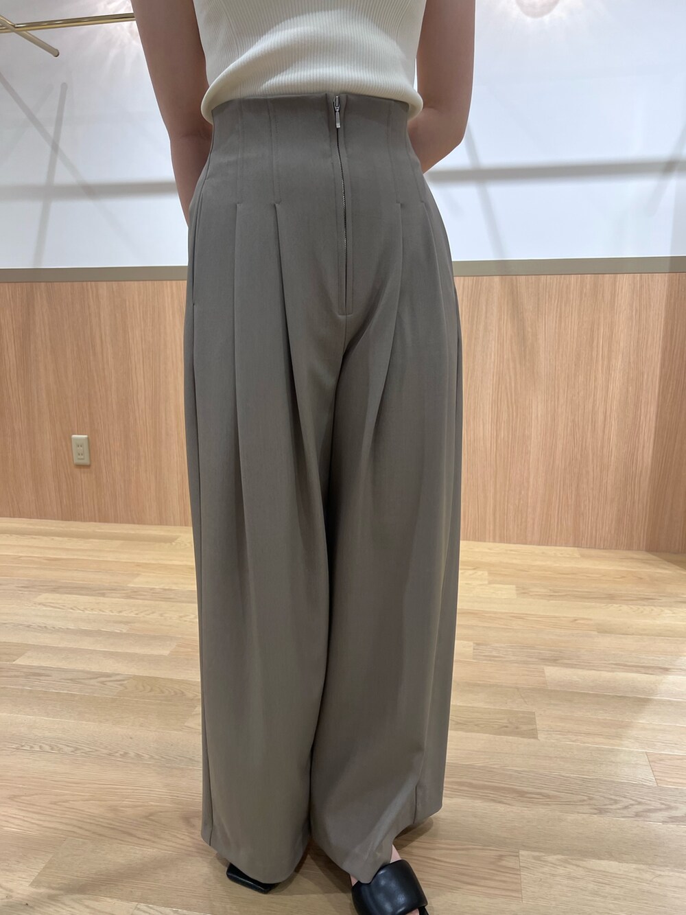 ブラウン系のその他パンツ、ブラック系のサンダル、ホワイト系のニット/セーターを着用したレディースの春コーディネートの6枚目の写真